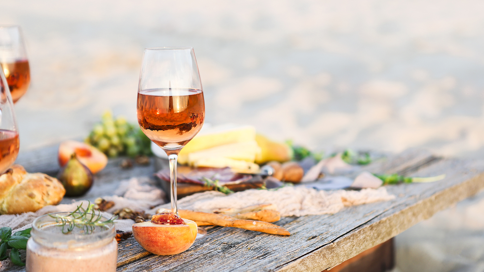 Glass of rose wine on rustic table. Food and drink background