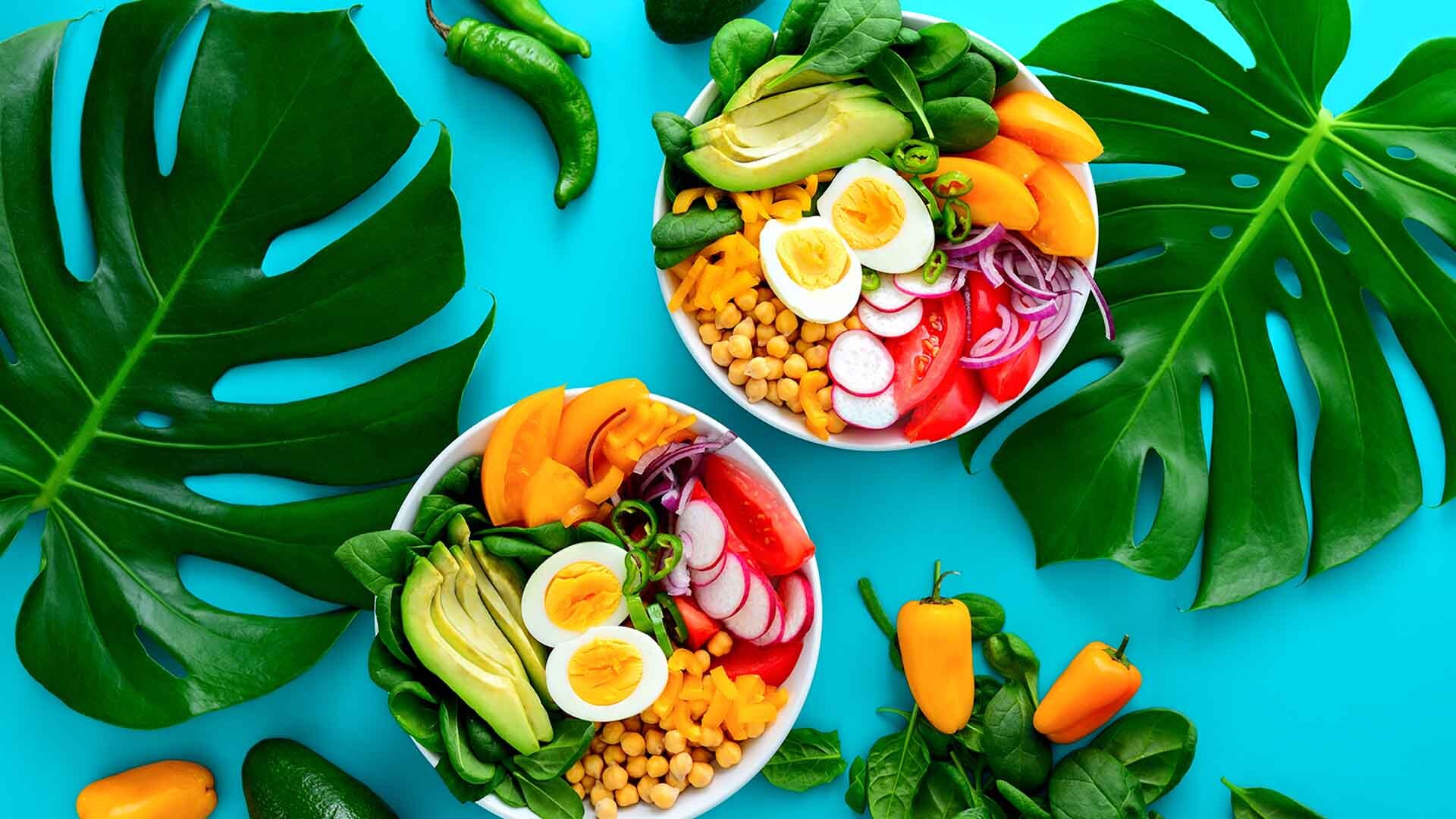 Freshly cooked Buddha bowl salad served on summer style decorated table, view from above, blank space for a text