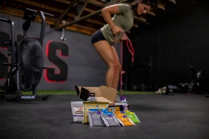 Contents of The Lift Box displayed with woman working out in background.