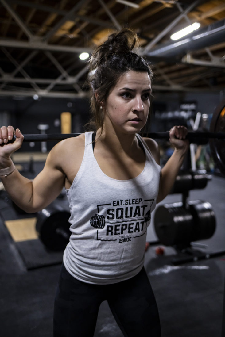 Woman lifting weights wearing the lift box tank top.