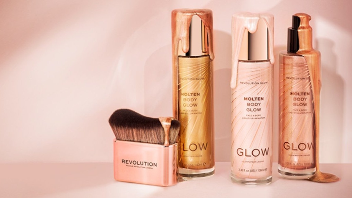 Three bottles of overflowing Molten Body Glow makeup and a set of brushes