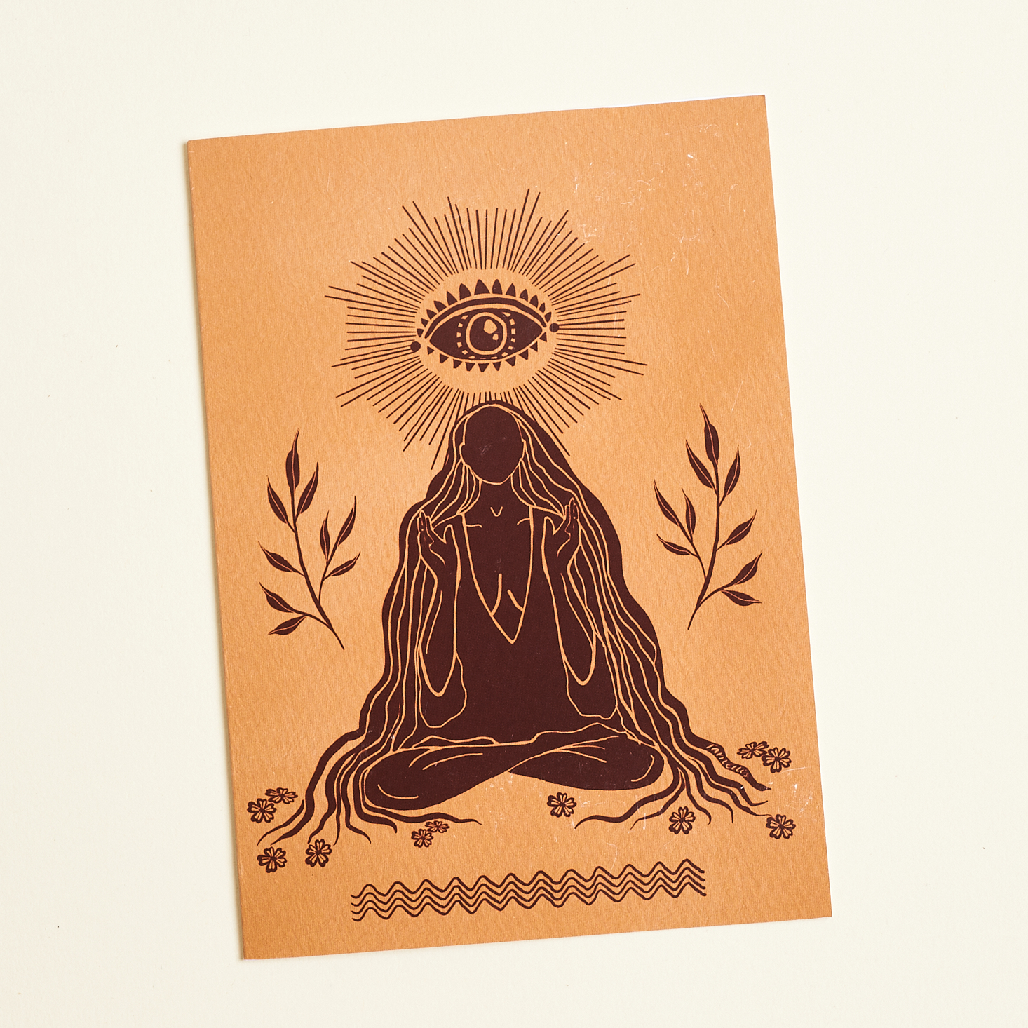 tan and brown card with woman on it, eye on top