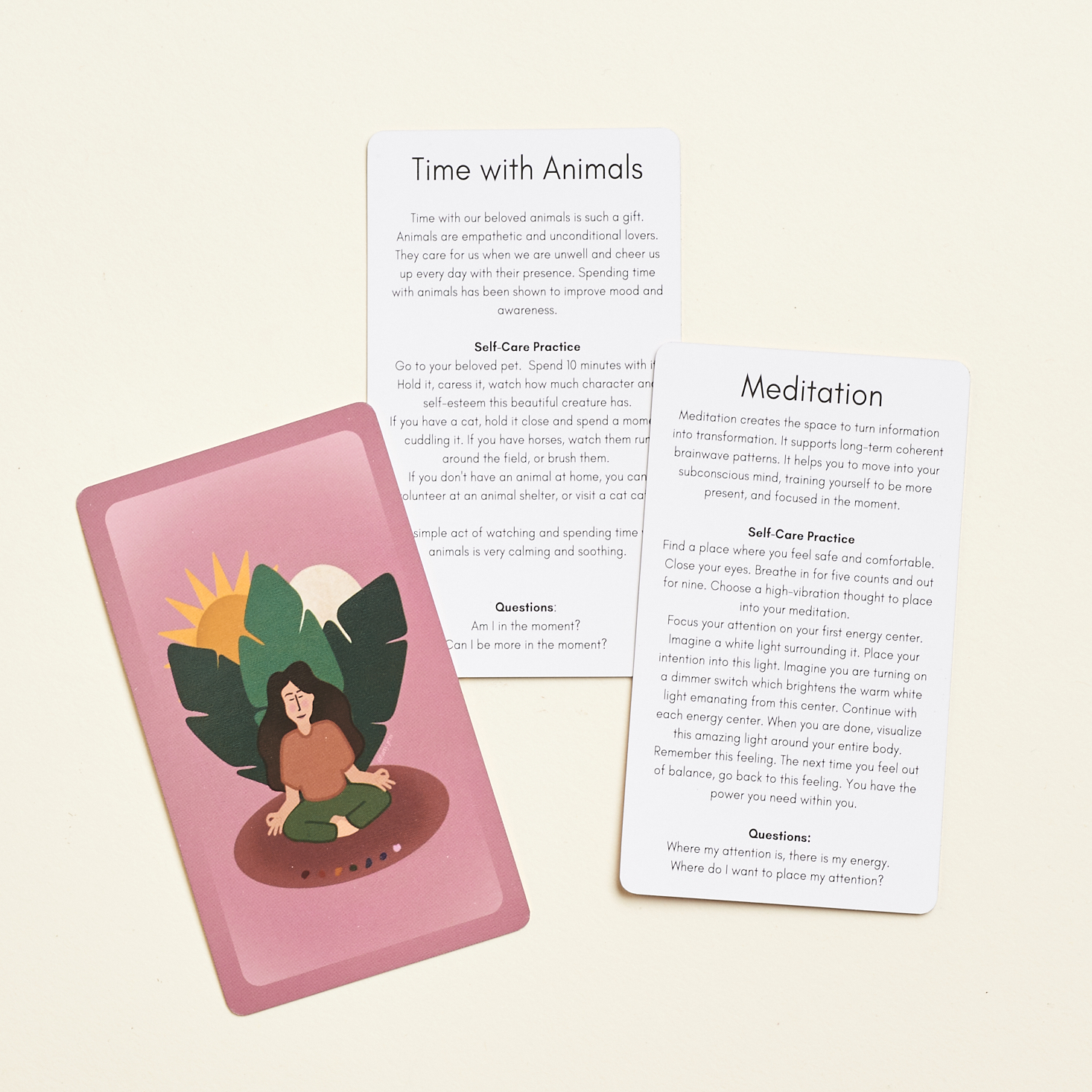 3 cards spread out, out pink with a woman sitting in front of plant. the other two cards are white with words