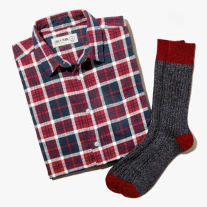 flannel shirt and one pair of socks laid flat on a white background