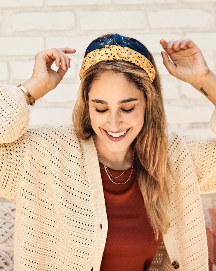 Photo of woman wearing two knotted Headbands of Hope, one mustard colored, one blue.