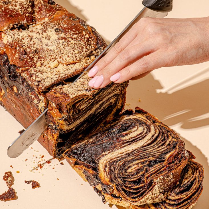 Photo of woman slicing through Oneg's Double Chocolate Babka