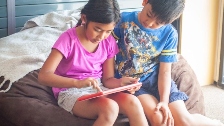 photo of girl and boy using mobile tablet