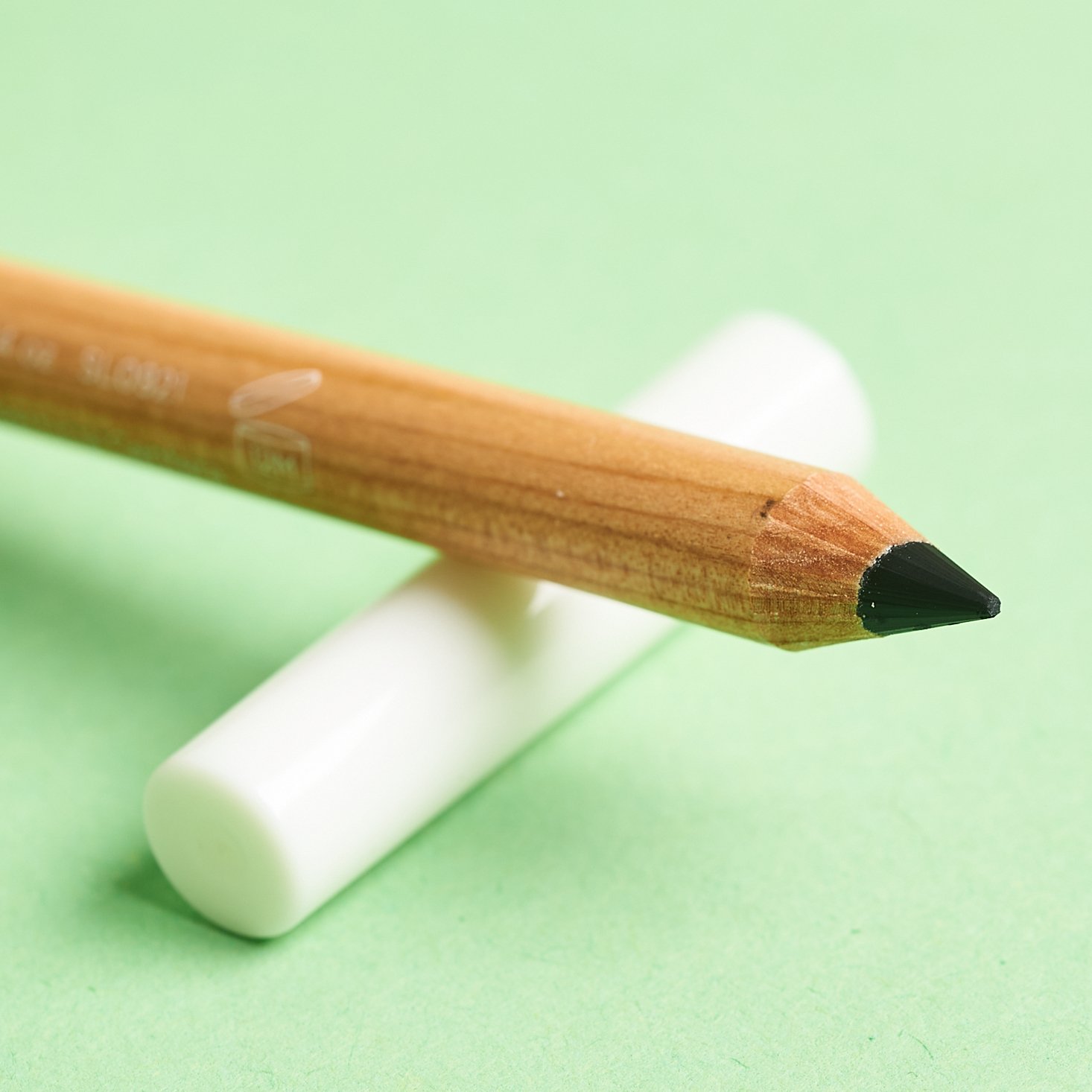 close up of eyeliner showing black tip resting on white lid