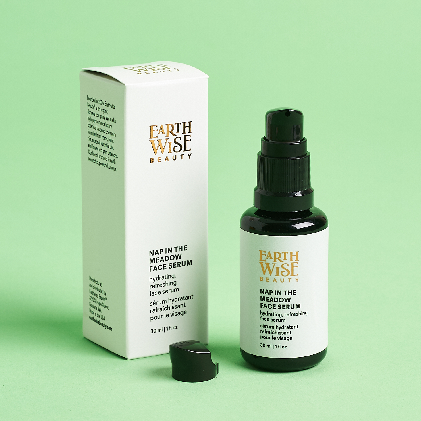 black and white serum bottle next to black packaging