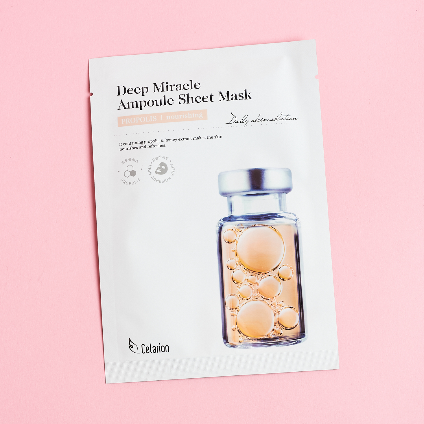 front of white sheet mask with pink medicine bottle on it