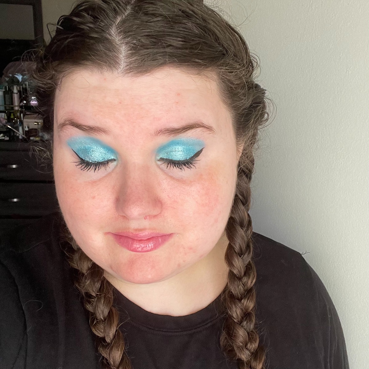 makeup look featuring sparkly blue eyeshadow with eyes closed