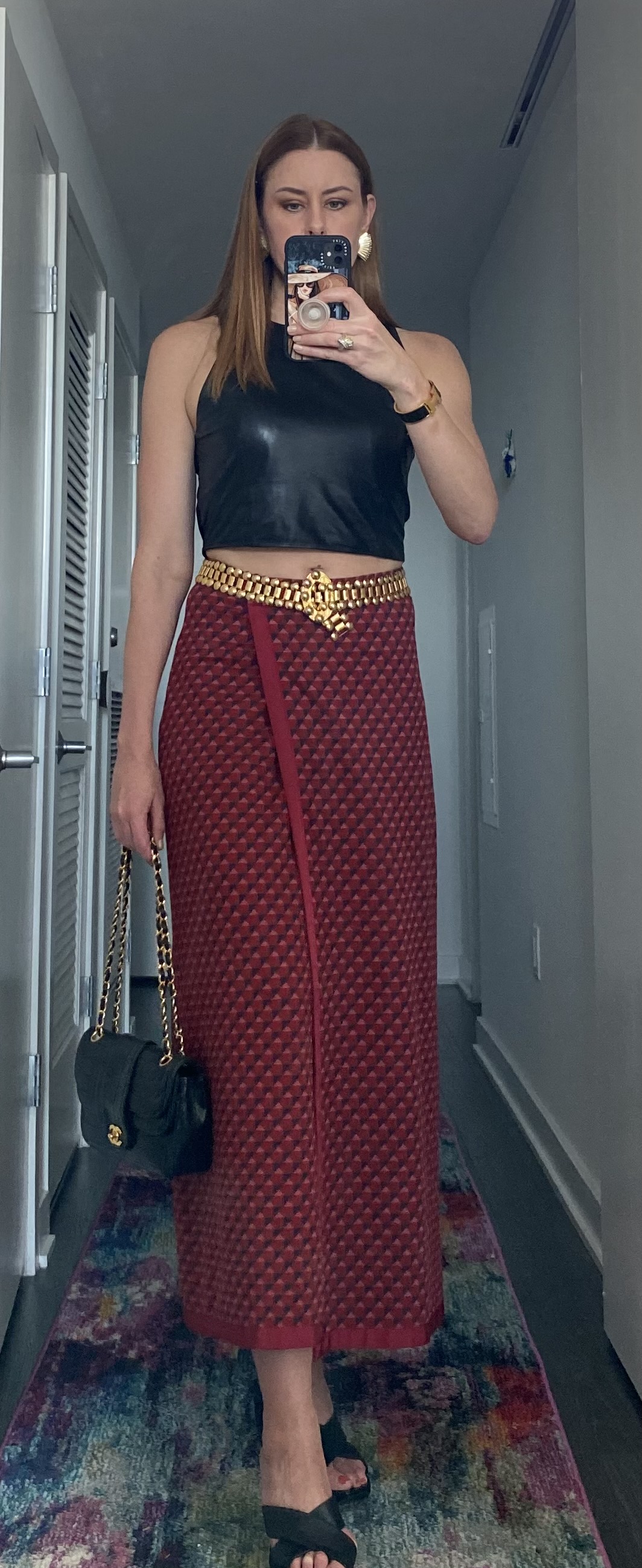 Women wearing red printed skirt with leather crop top and gold belt