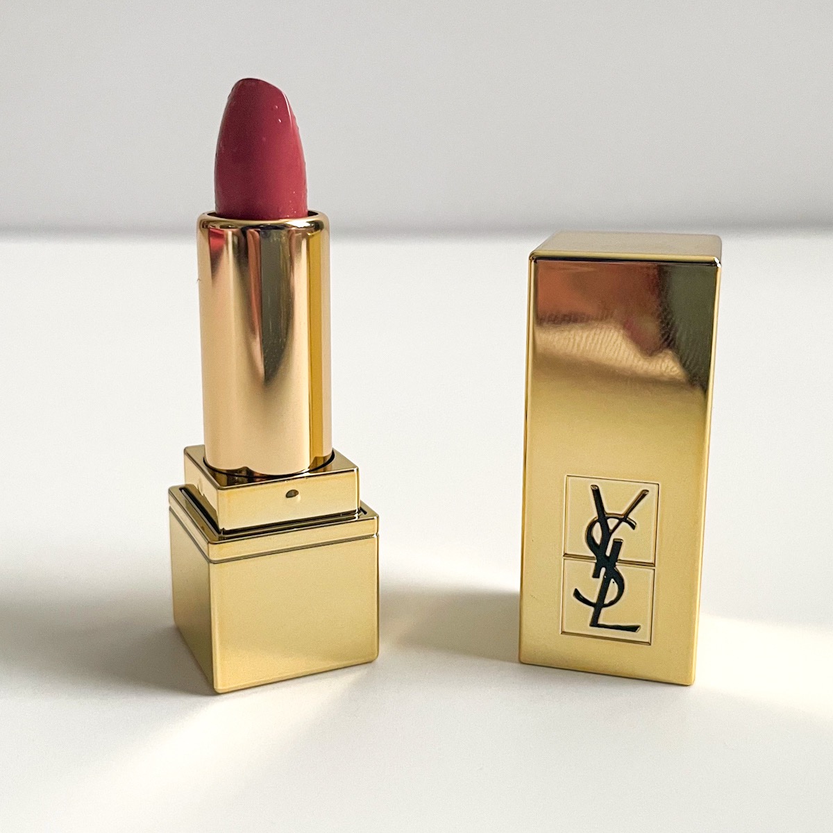 gold lipstick tube opened to show nude lipstick color