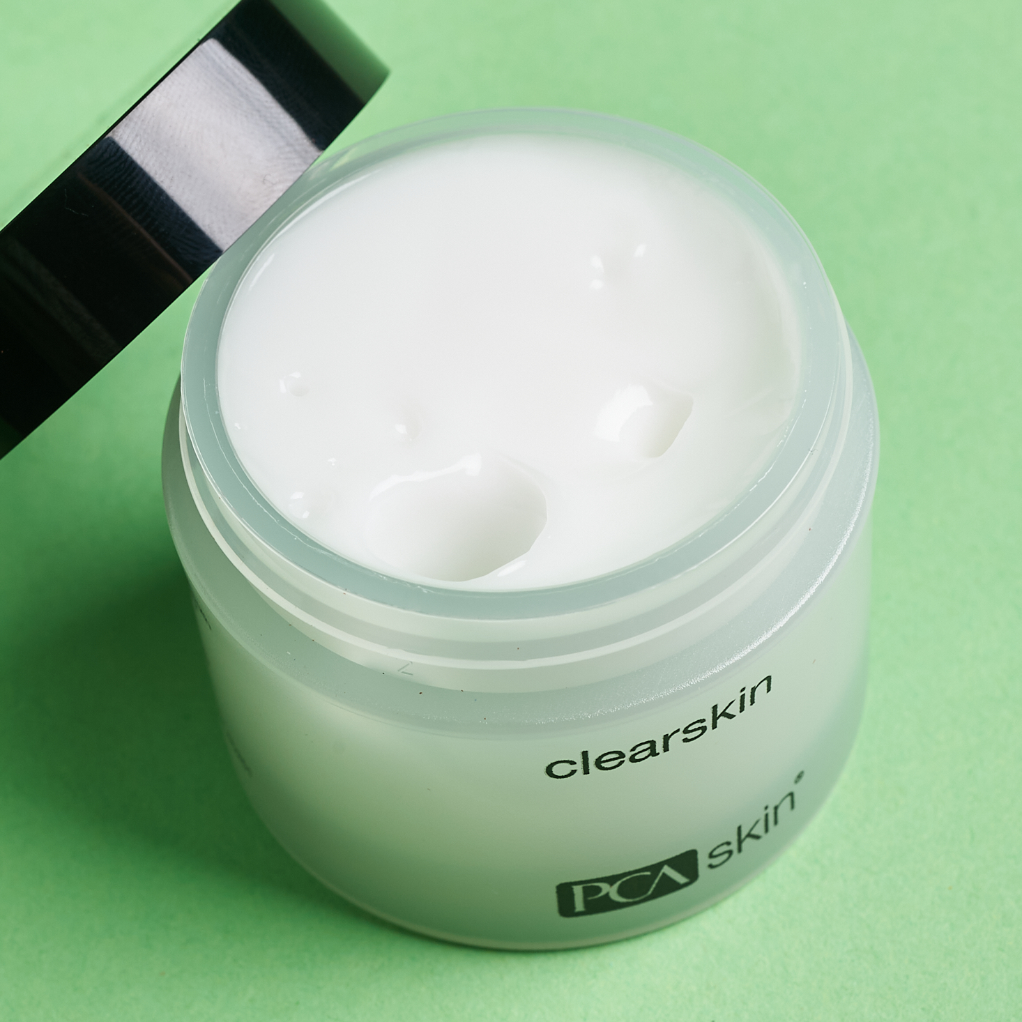 open white jar showing white texture of moisturizer