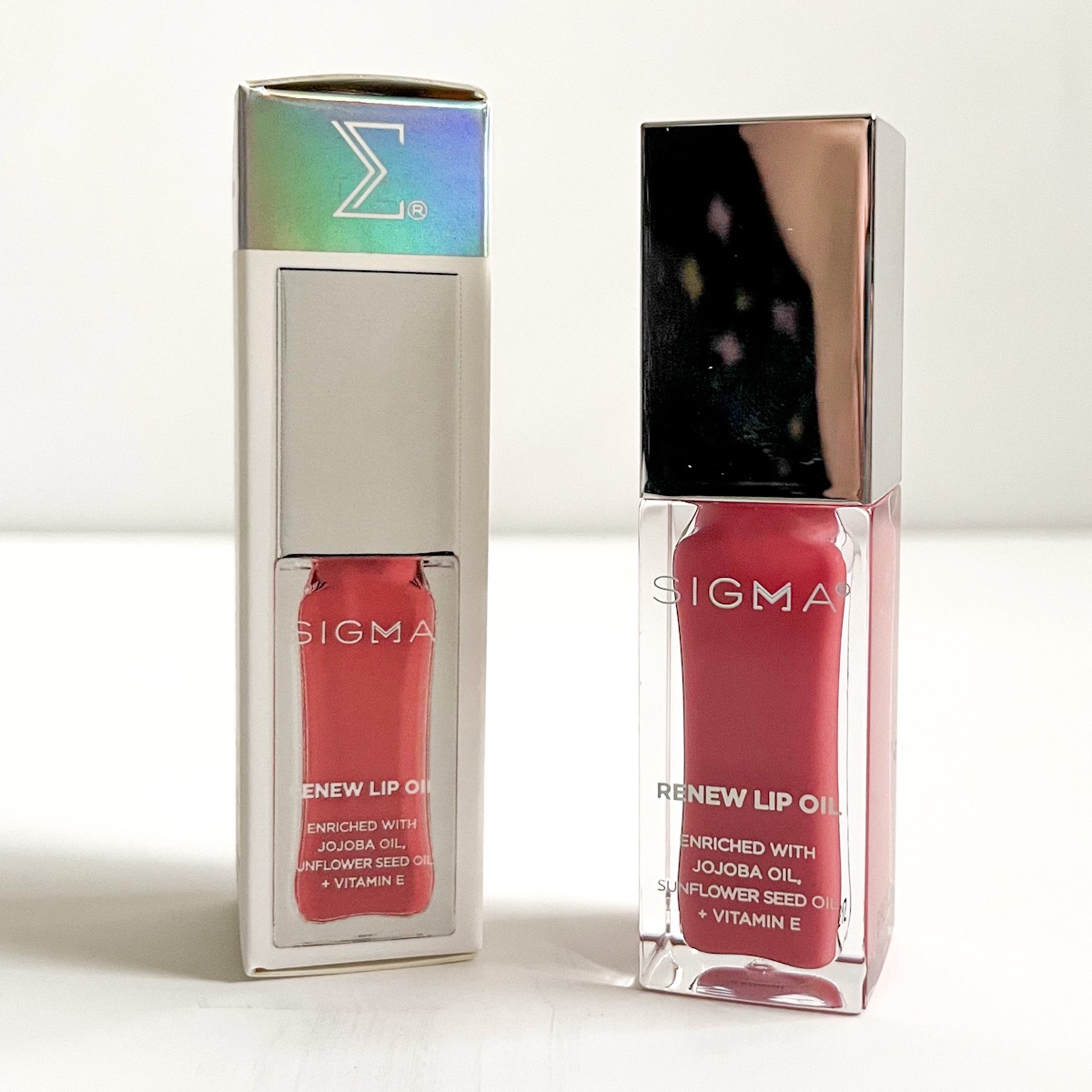 pink tube of lip oil with silver lid standing next to the box it came packaged in
