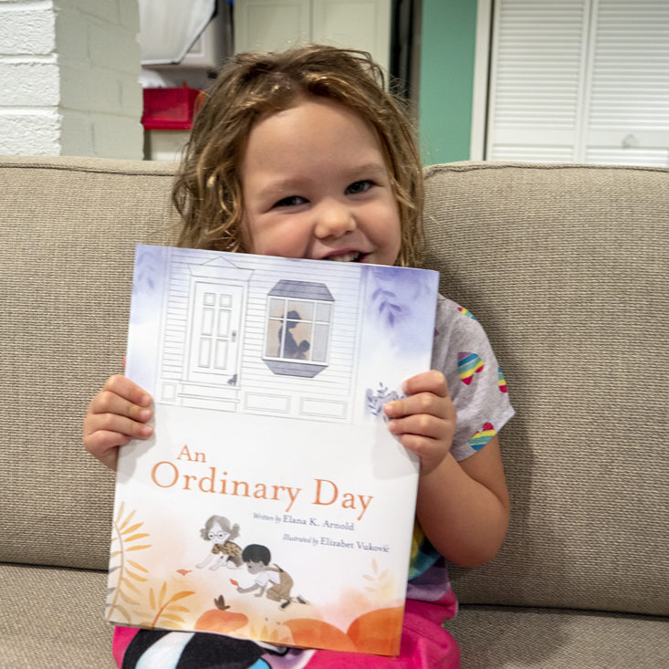 little girl holding book from little feminist