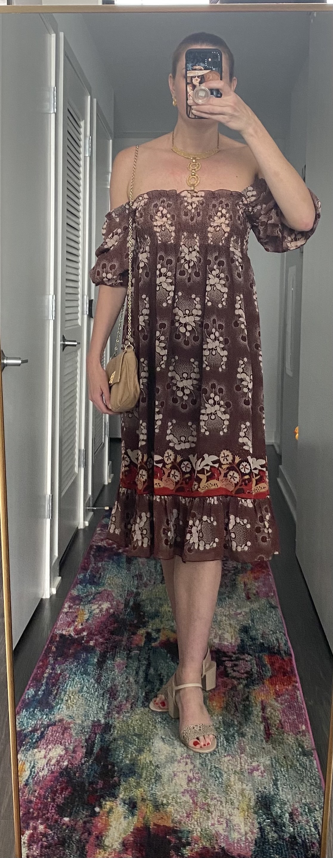 Woman wearing printed off-the-shoulder dress with handbag on shoulder