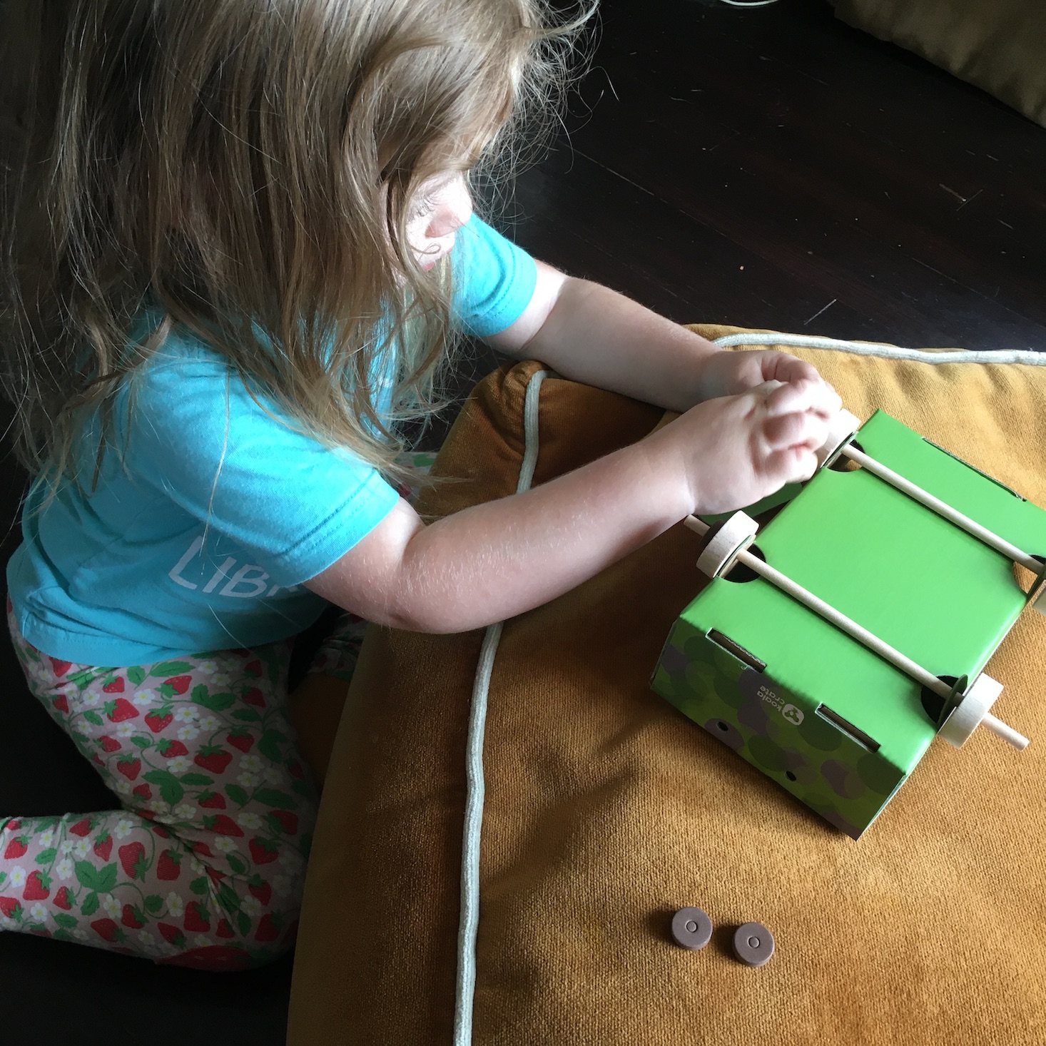 Kid putting wheels on a toy wagon