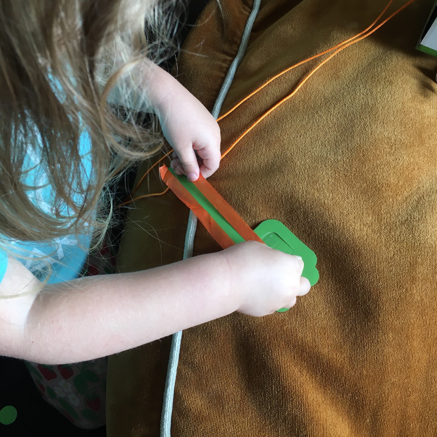 Kid adding tissue paper "fire" to a paper dragon