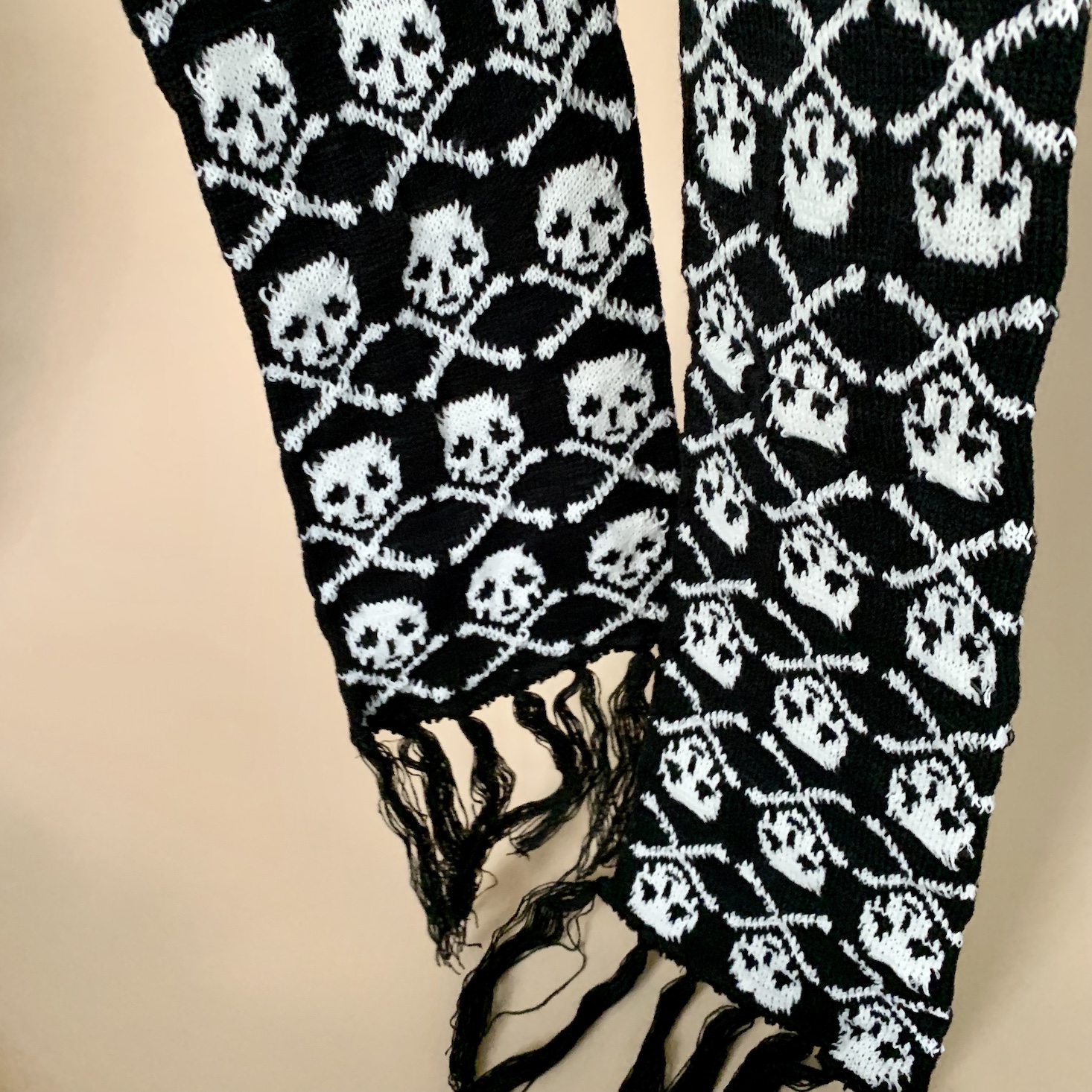 black scarf with skull and crossbones stitched in an allover print