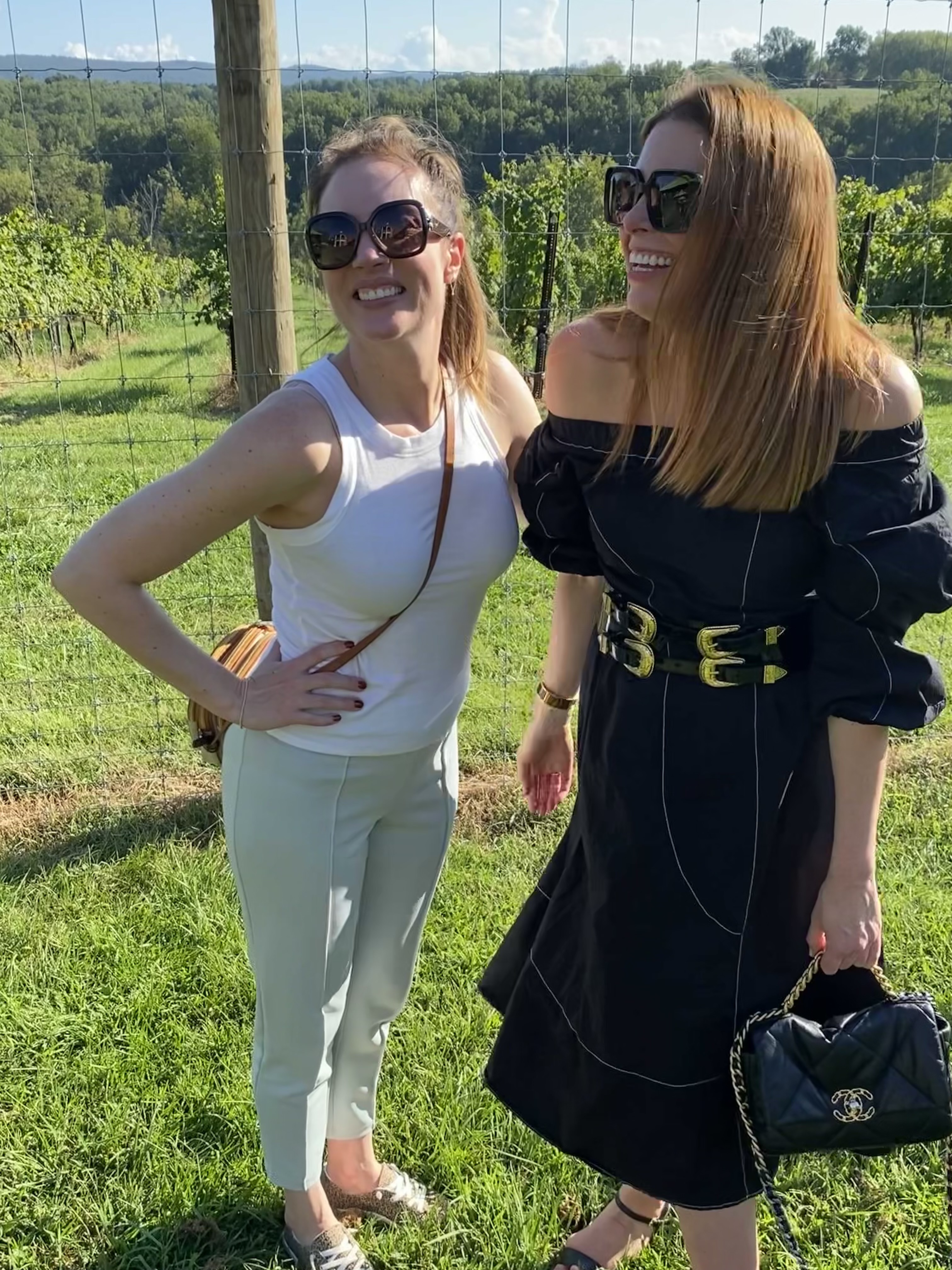 Two women smiling and laughing at a vineyard
