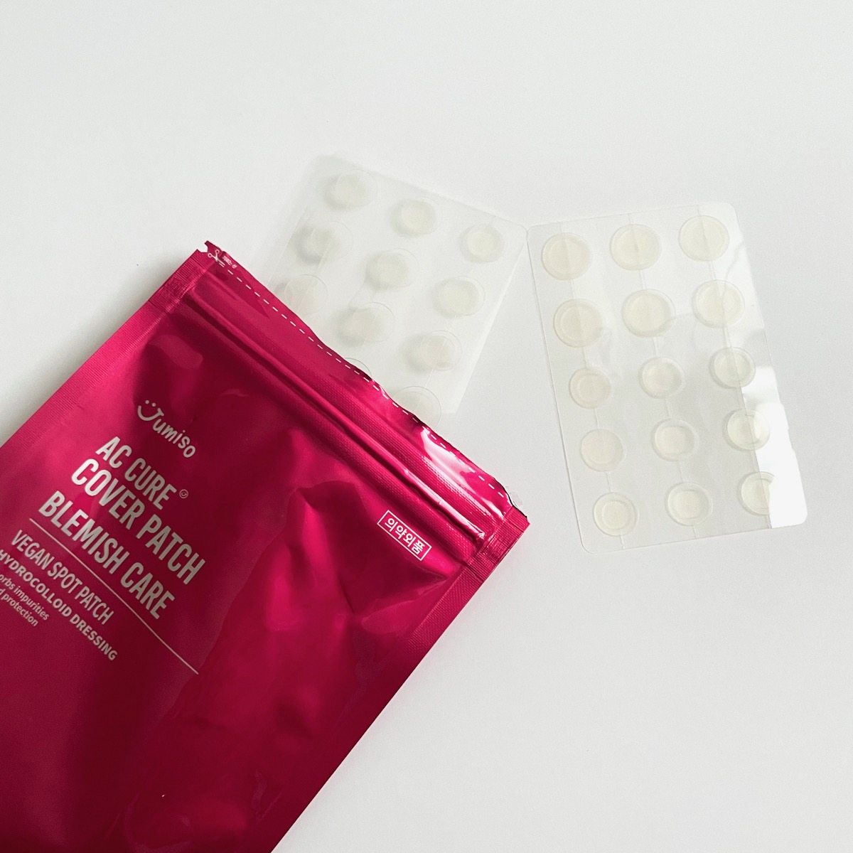 opened red packaging showing two sizes of clear pimple patches