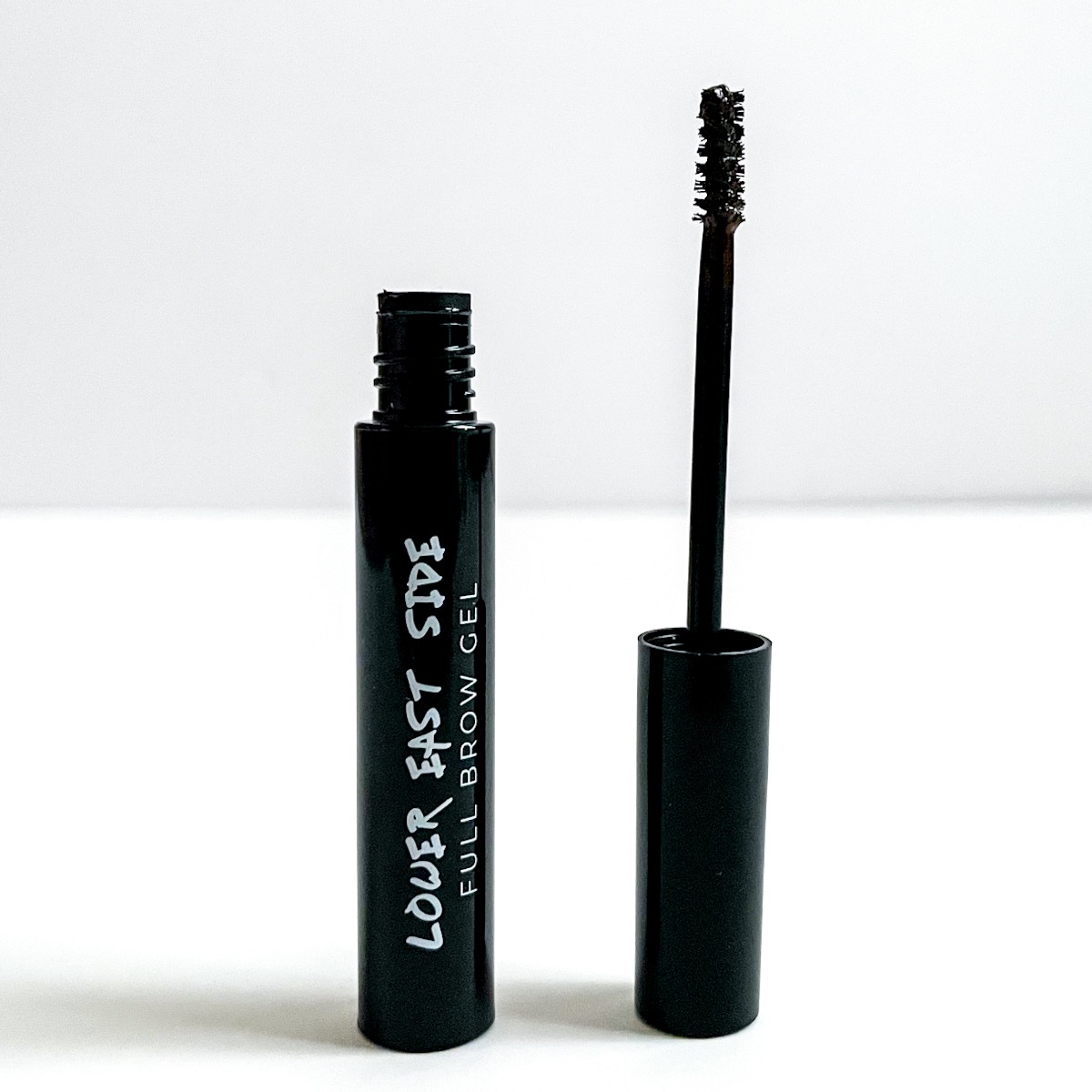 opened black tube of brow gel showing small brush
