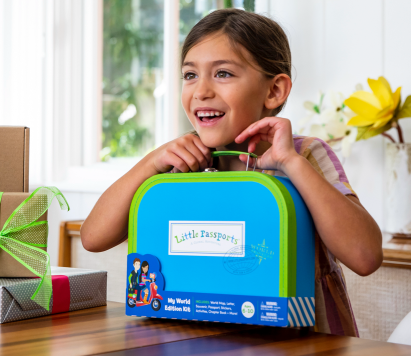 Little girl holding Little Passports suitcase