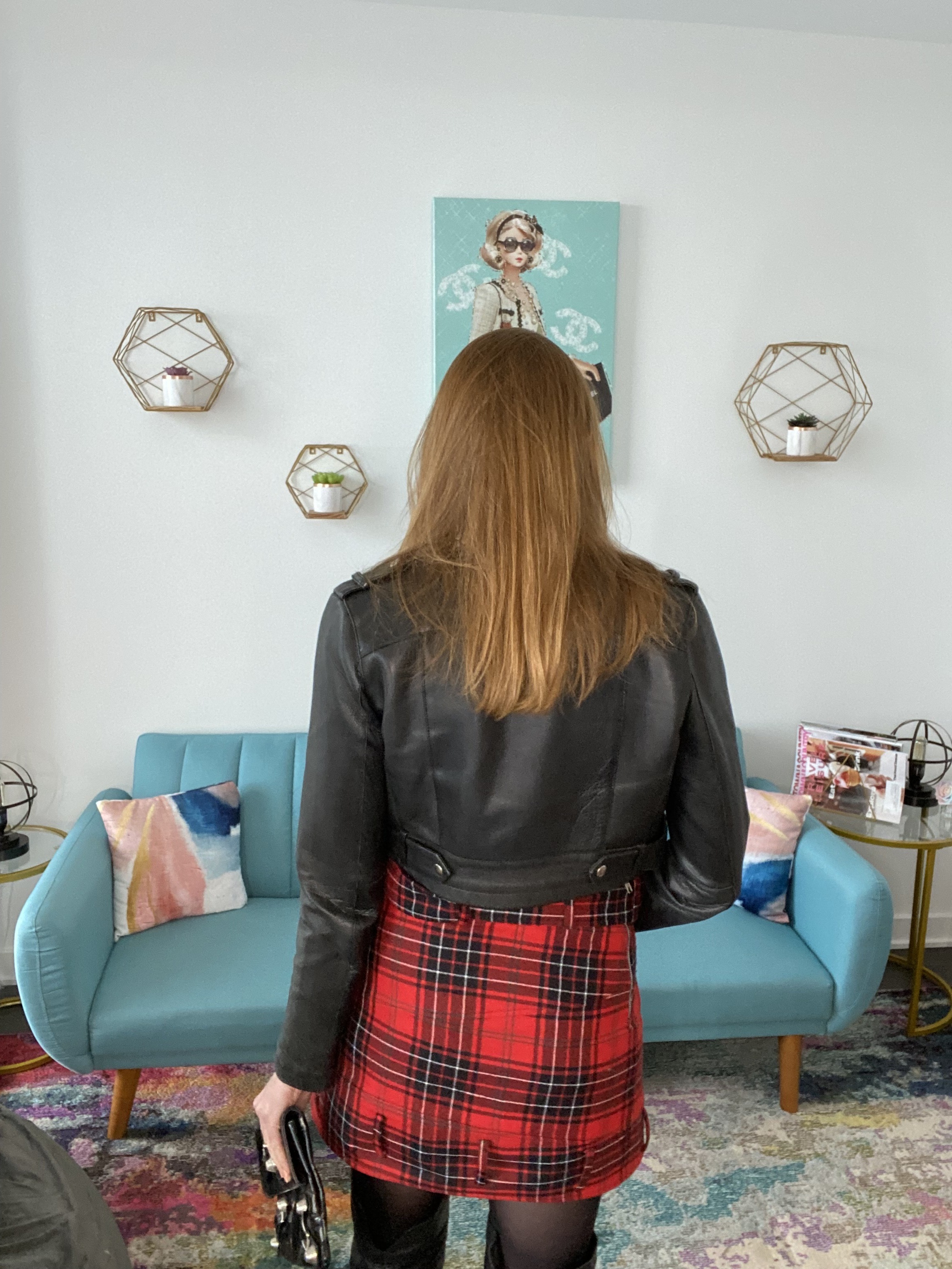 Woman in black leather jacket and plaid skirt