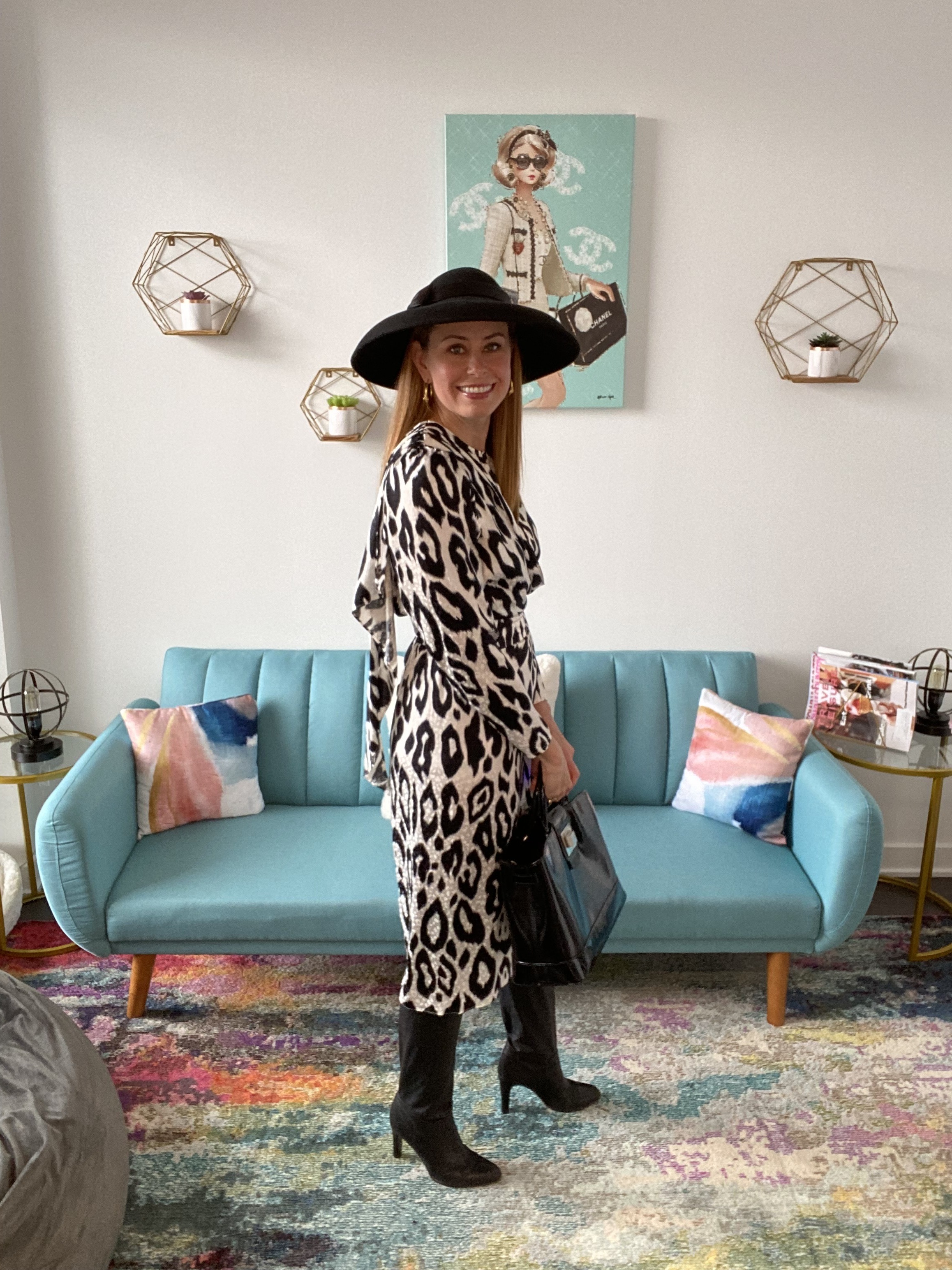 Woman in black and white zebra-printed dress with boots and hat