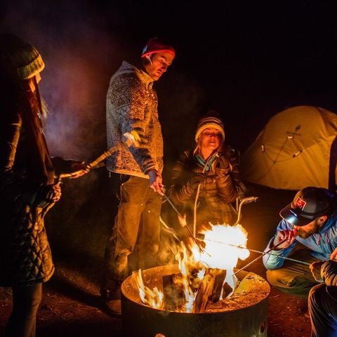 people around a campfire in the dark