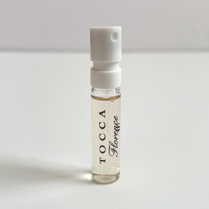 clear perfume vial with black lettering and white nozzle