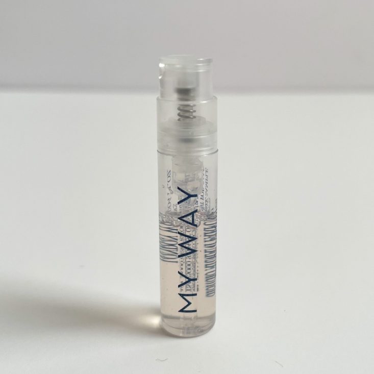 clear perfume vial with black lettering and white nozzle