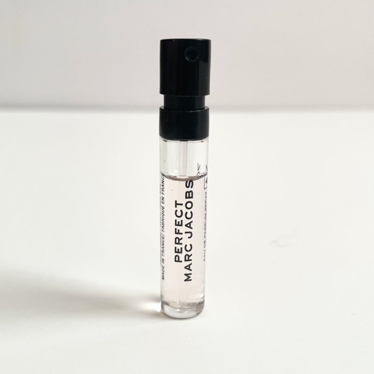 clear perfume vial with black top and light pink perfume liquid