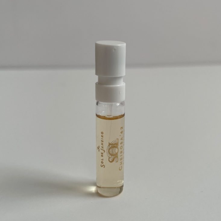 clear perfume vial with black lettering and white nozzle