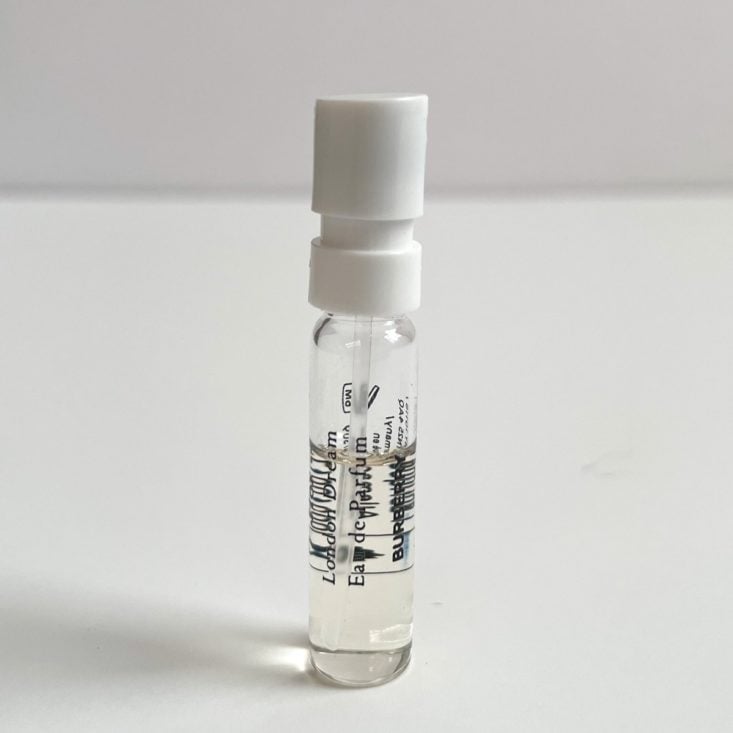 clear perfume vial with black lettering and white nozzle