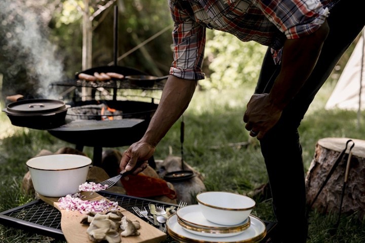 man making food on a campfire