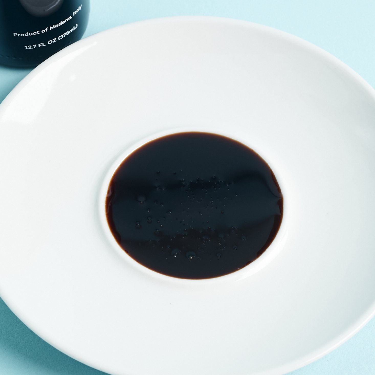 deep brown balsamic vinegar in a white dish