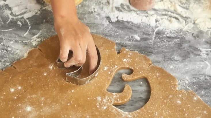 photo of a hand using the Glossier cookie cutter to cut through dough
