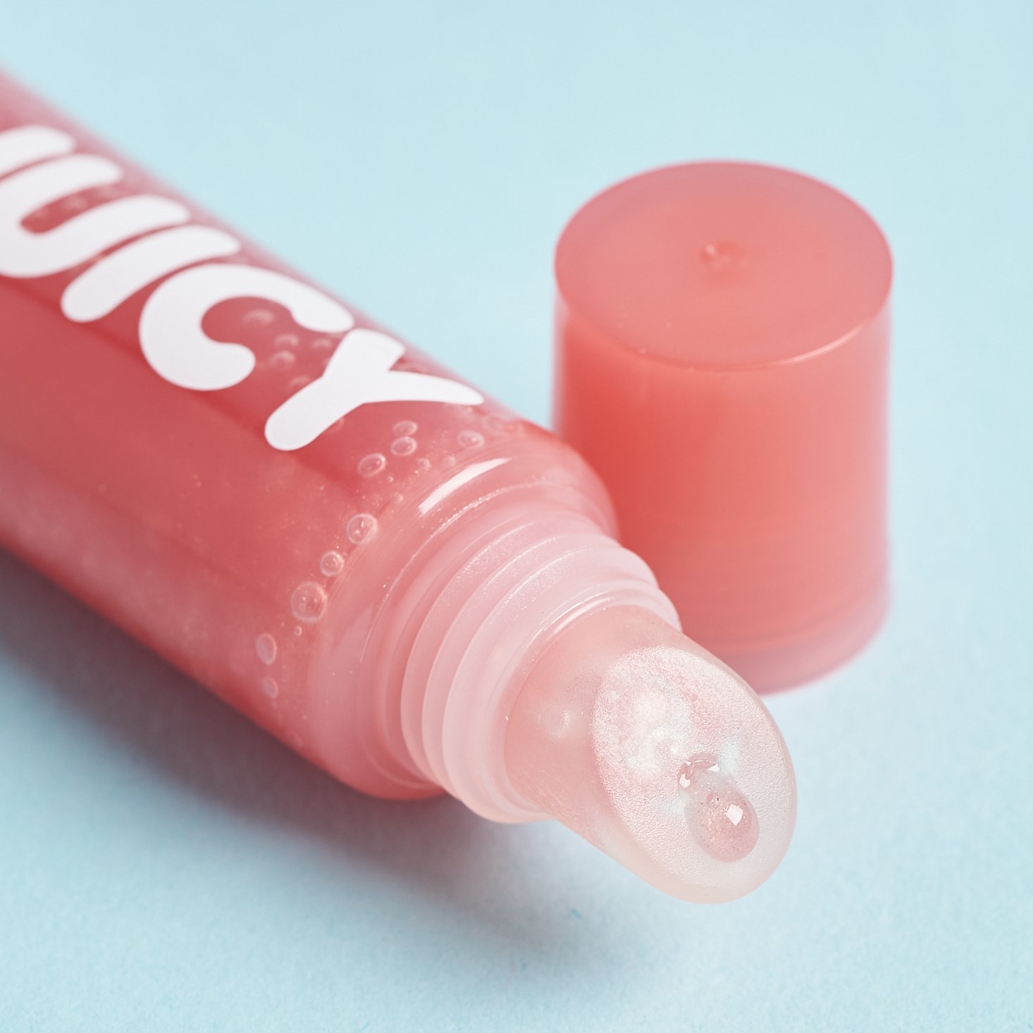 opened pink lip gloss tube showing applicator