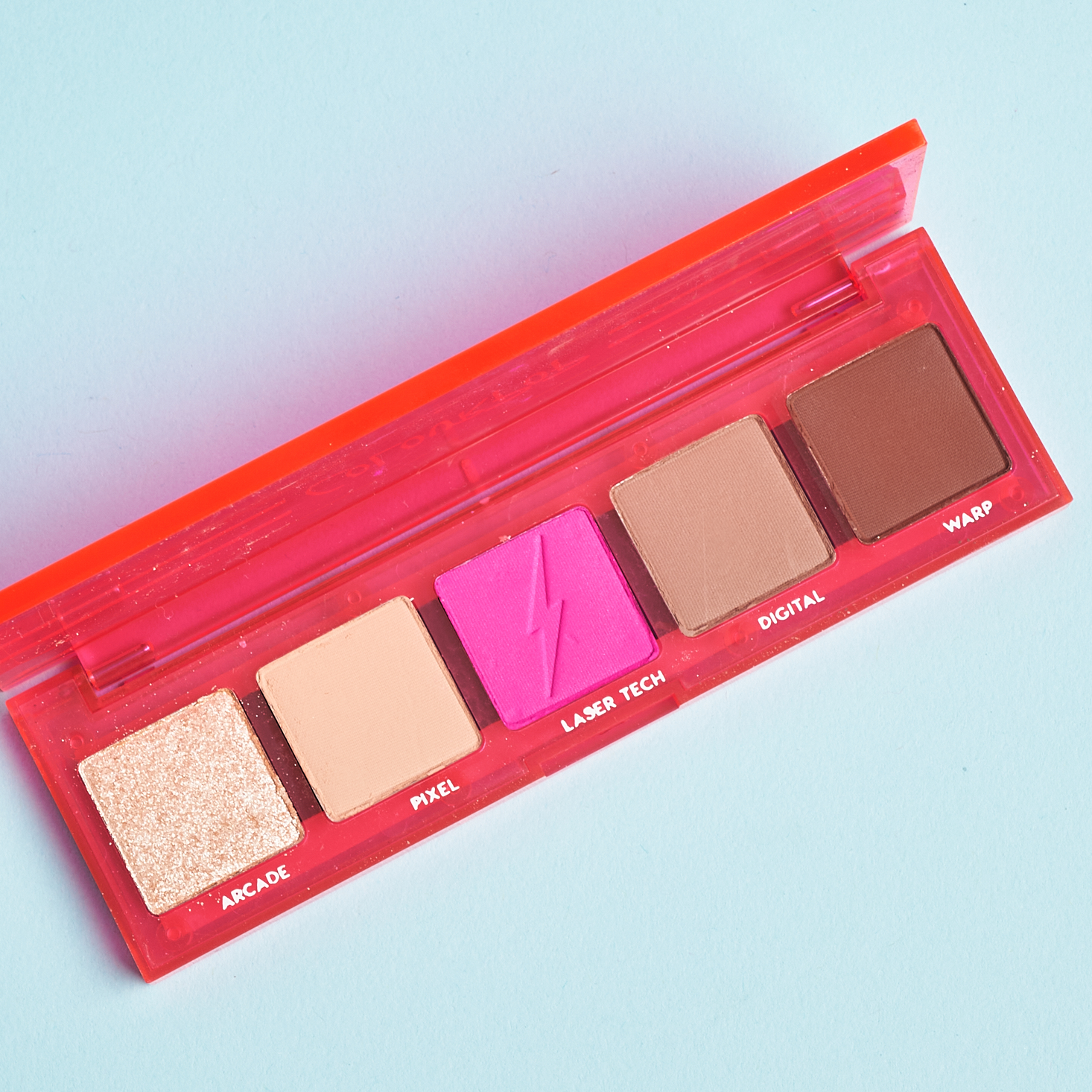 opened Neon pink plastic eyeshadow palette showing four brown shades and a neon pink shade