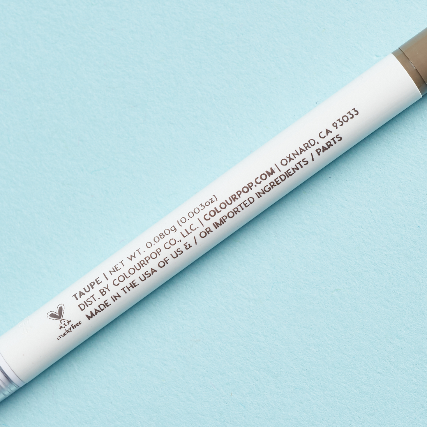 close up of product information on white body of brow pencil