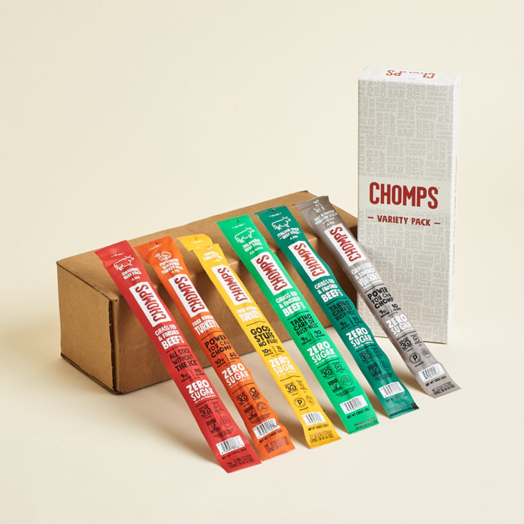 Chomps box and six different jerky sticks in wrappers leaned up against the box