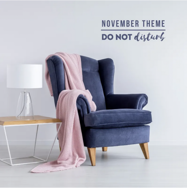 November theme do not disturb chair with blanket on it and a table with a lamp beside it