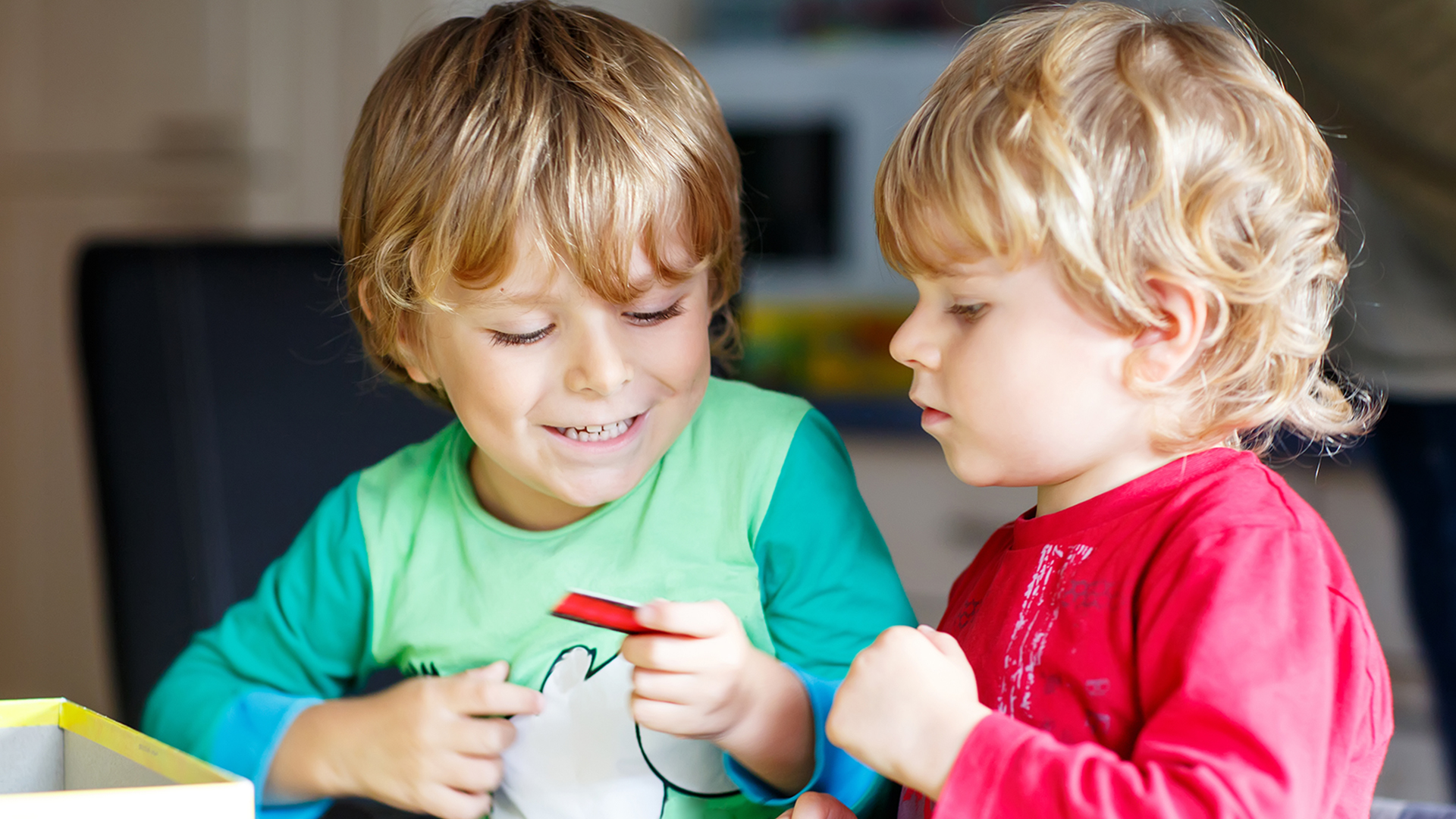 Two little blond kid boys playing together board game at home. Funny siblings having fun. Twins and best friends, toddlers learning interact, win and lose.