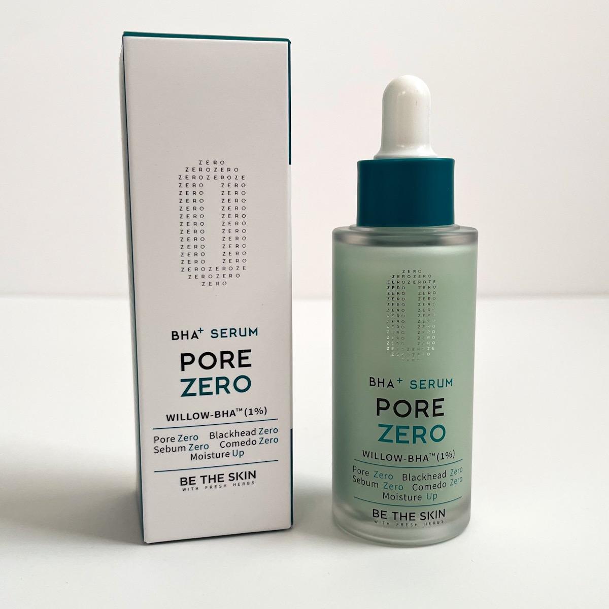 blue-green bottle next to white box it came packaged in