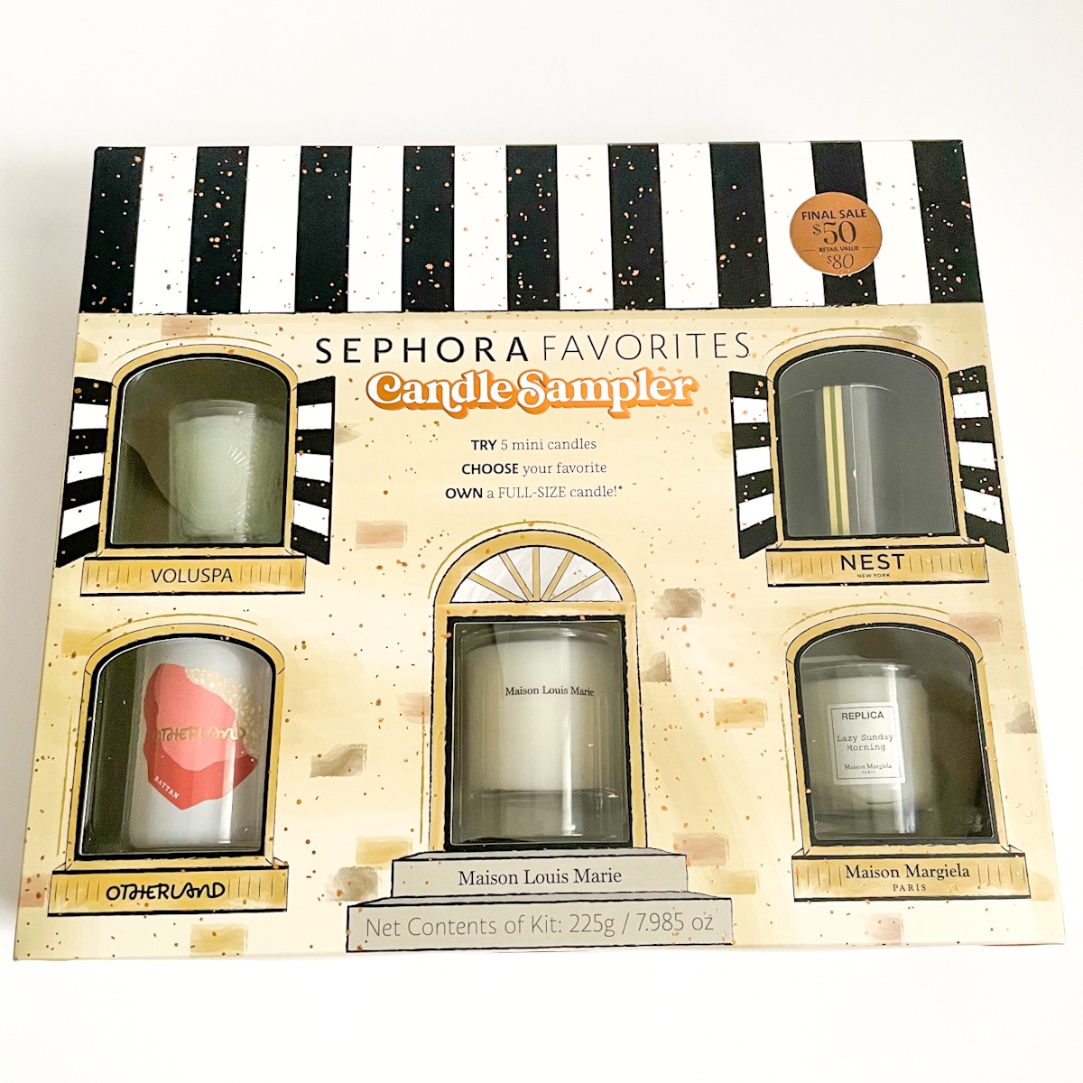 front of packaging showing candles in the window of what looks like a house