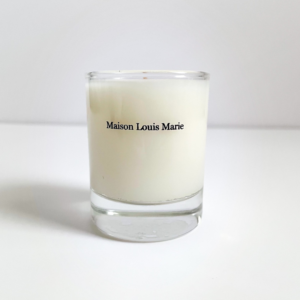 clear glass candle with black lettering of brand name