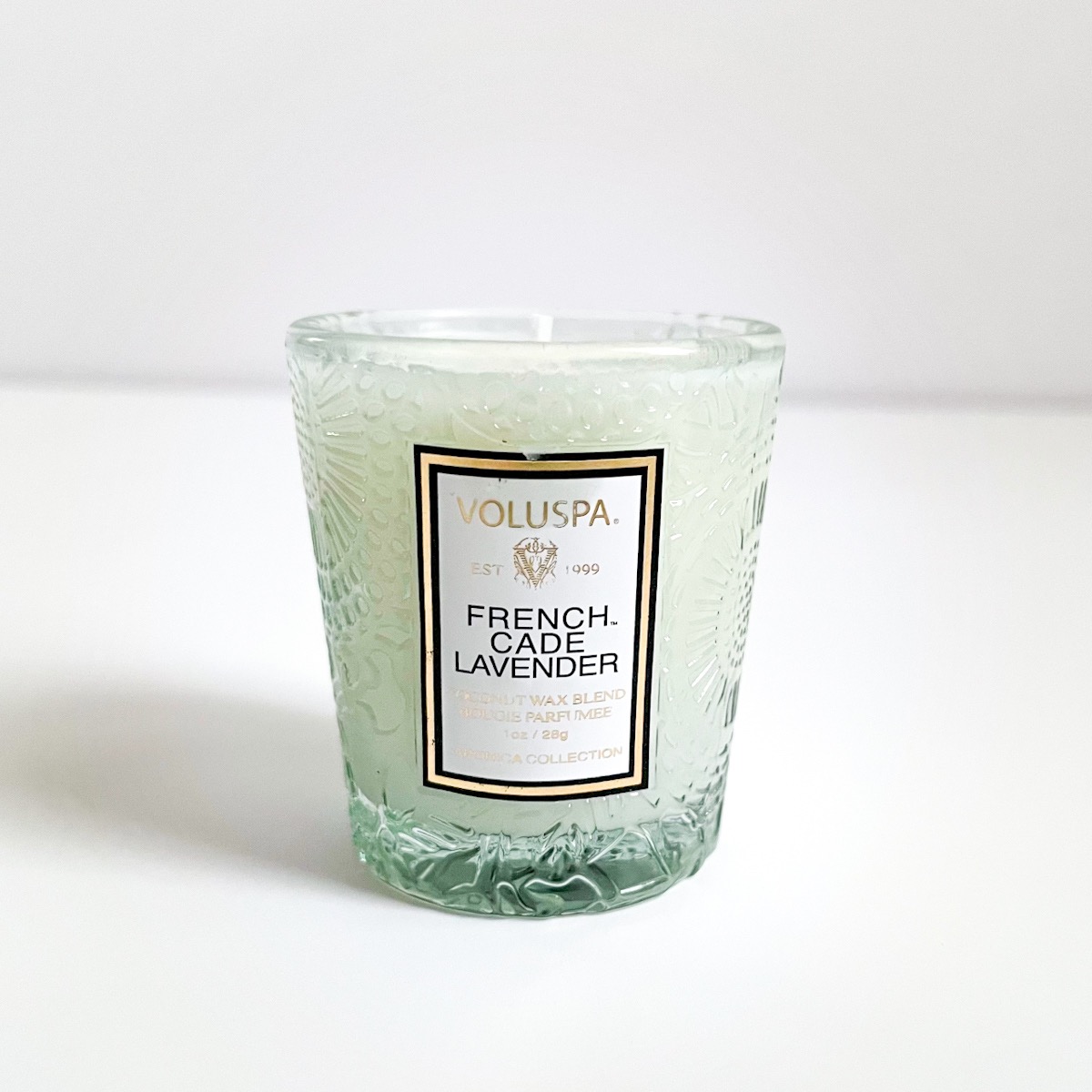 frosted light blue glass candle with white label