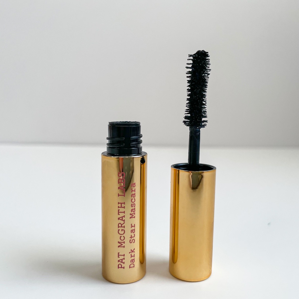 opened gold tube of mascara with fluffy mascara wand